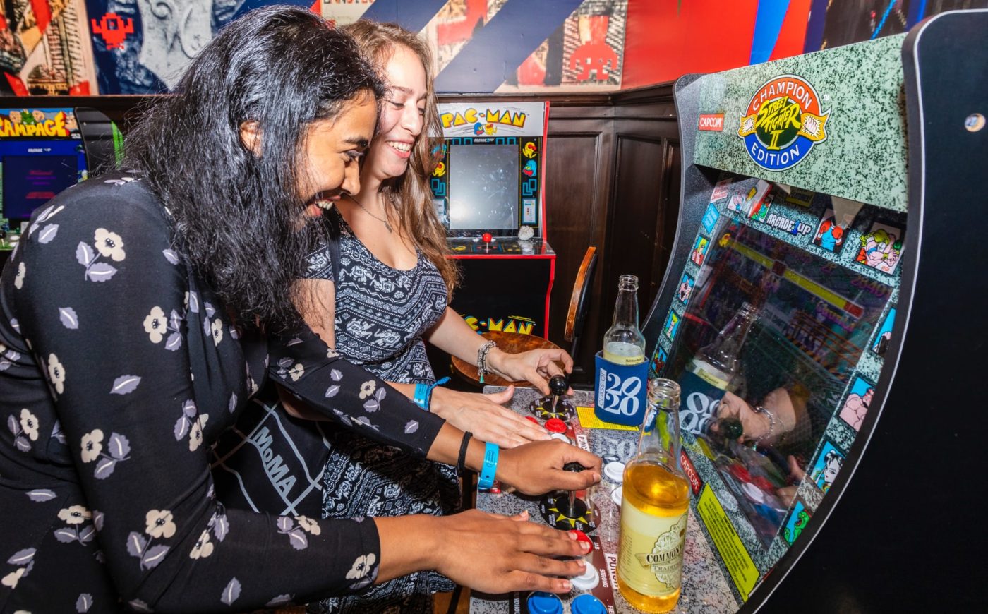 Friends playing arcade games at Penn it Forward