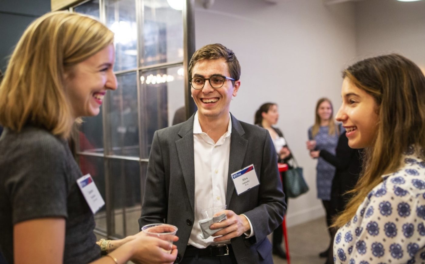 Young Alumni talking and laughing at NYC event